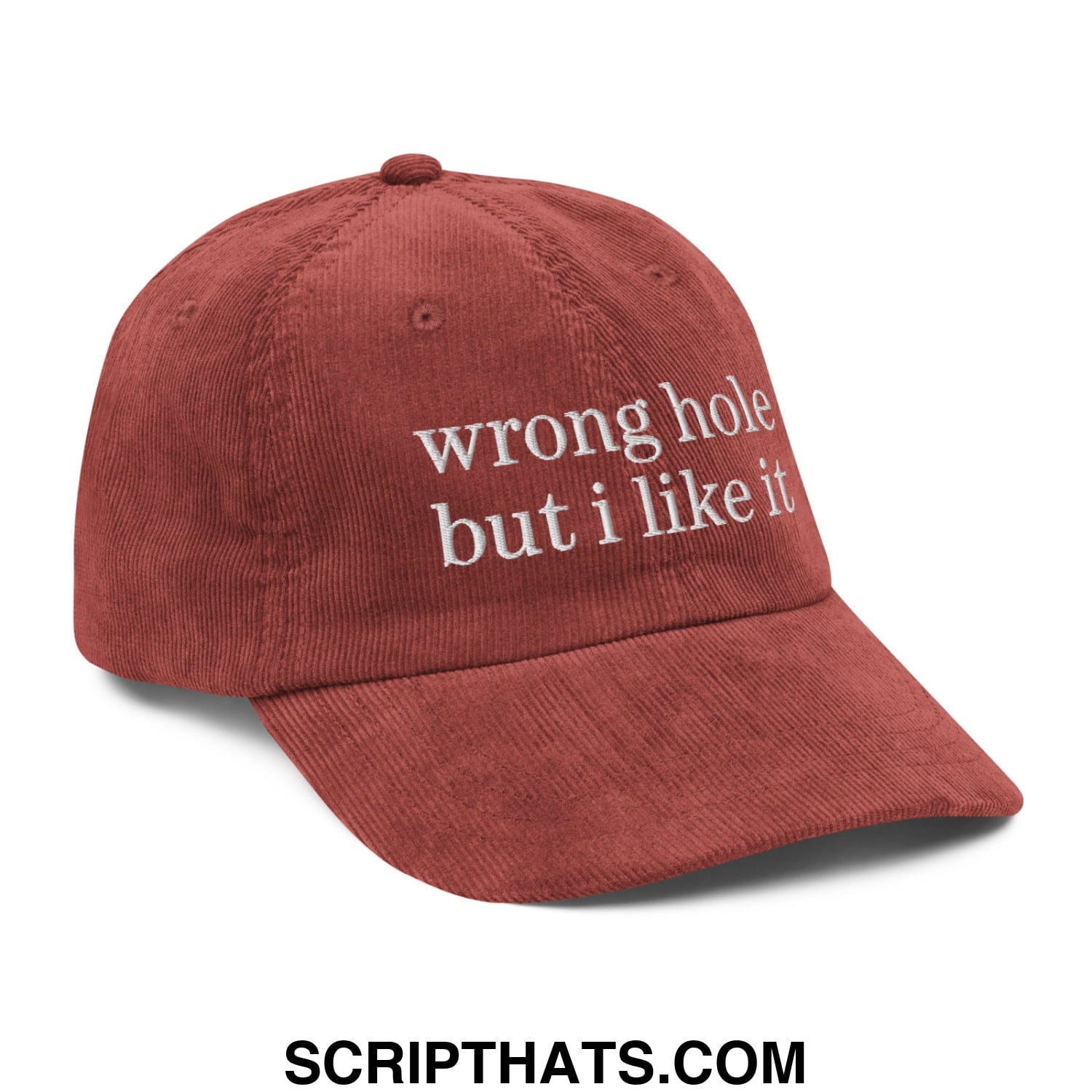 A rust-colored unstructured corduroy dad hat with white embroidered text reading wrong hole but i like it