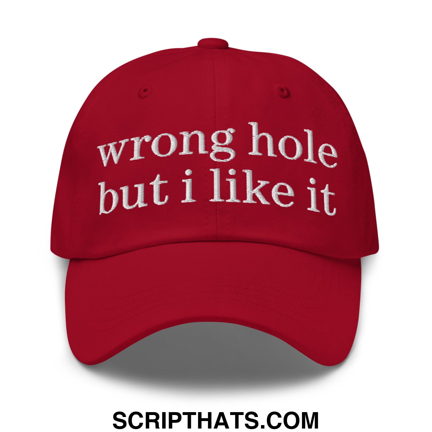 A vibrant red unstructured dad hat with white embroidered text reading wrong hole but i like it