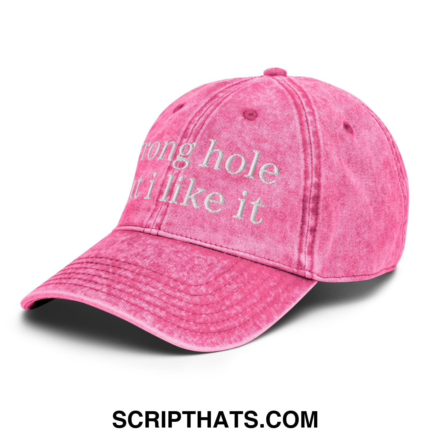 A faded pink unstructured denim dad hat with white embroidered text reading wrong hole it i like it