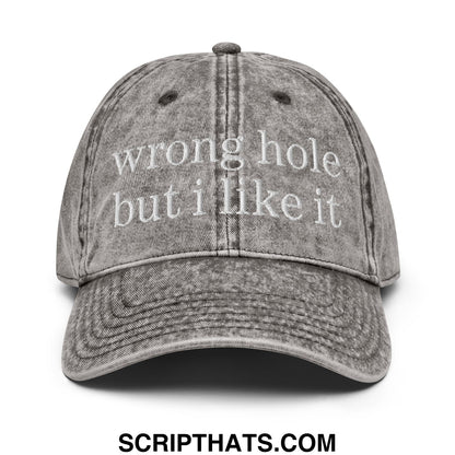 A faded gray denim baseball dad hat with white embroidered text wrong hole but i like it on front panel