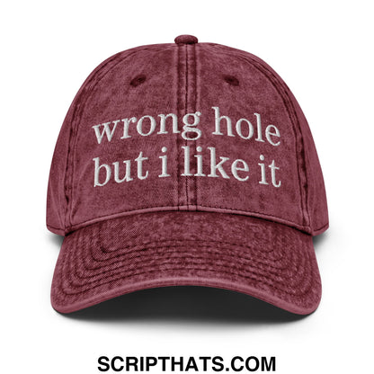 A maroon distressed cotton baseball cap with white embroidered wrong hole but i like it text unstructured dad hat